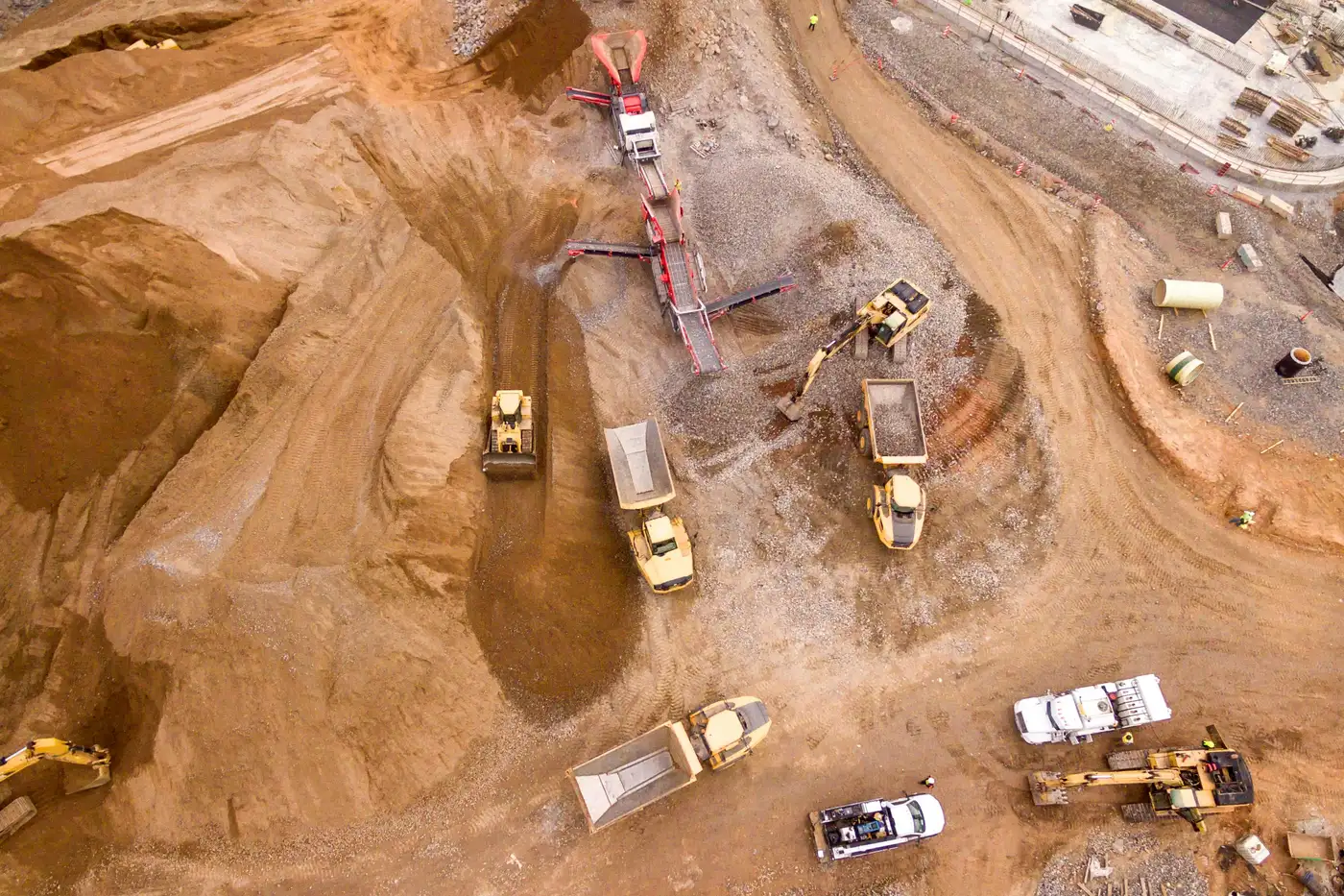 An open-pit site with excavators and dump trucks, seen from above